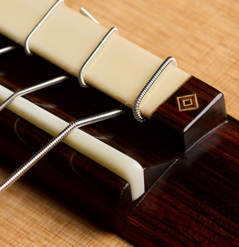The bridge, tie-block and saddle of a 2026 Jochen Röthel classical guitar made of cedar and African rosewood