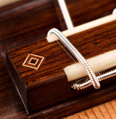 A close-up of the bridge and ornament of a 2019 Jochen Rothel classical guitar made of cedar and cypress