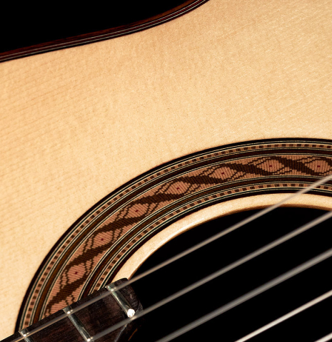 The soundboard and rosette of a 2023 German Vazquez Rubio "Solista" classical guitar made of spruce and Indian rosewood