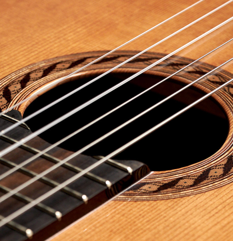 The nylon strings and rosette of a 2023 German Vazquez Rubio &quot;Classic Estudio&quot; classical guitar made of cedar and palo escrito