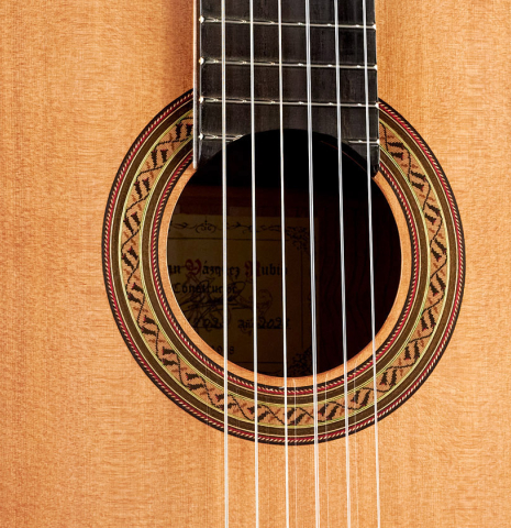 The soundboard and rosette of a 2023 German Vazquez Rubio &quot;Classic Estudio&quot; classical guitar made of cedar and palo escrito