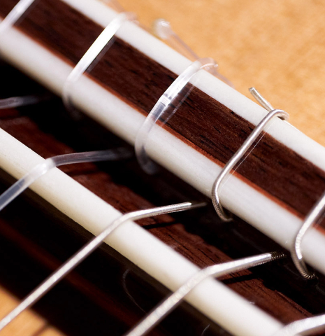 The bridge, tie-block and saddle of a 2023 German Vazquez Rubio &quot;Classic Estudio&quot; classical guitar made of cedar and palo escrito
