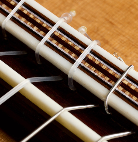 The bridge, tie-block and saddle of a 2026 German Vazquez Rubio "Solista" classical guitar made of cedar and Indian rosewood