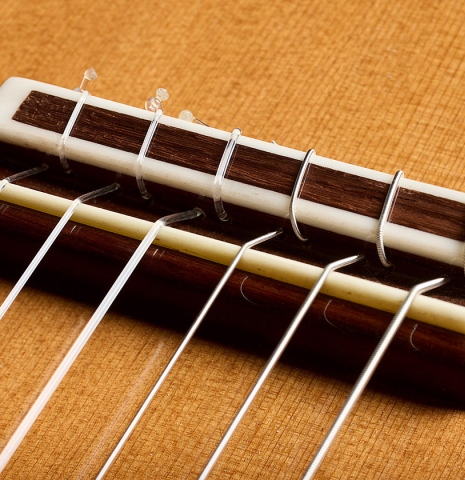 The bridge, tie-block and saddle of a 2026 German Vazquez Rubio "Solista" classical guitar made of cedar and Indian rosewood