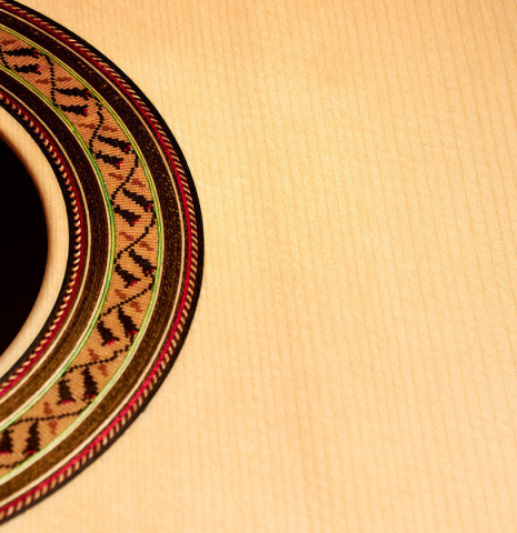 The soundboard and rosette of a 2022 German Vazquez Rubio "Classic Estudio" classical guitar made of spruce and Palo Escrito.