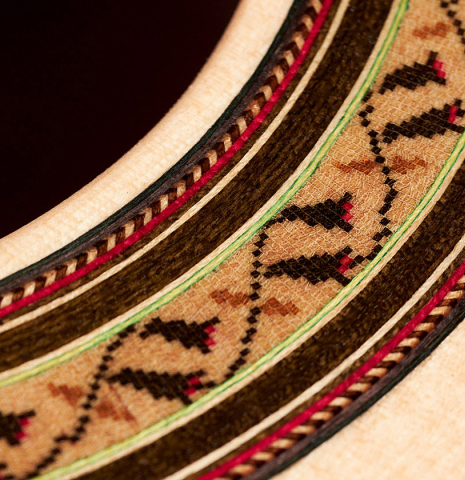 The soundboard and rosette of a 2022 German Vazquez Rubio "Classic Estudio" classical guitar made of spruce and Palo Escrito.