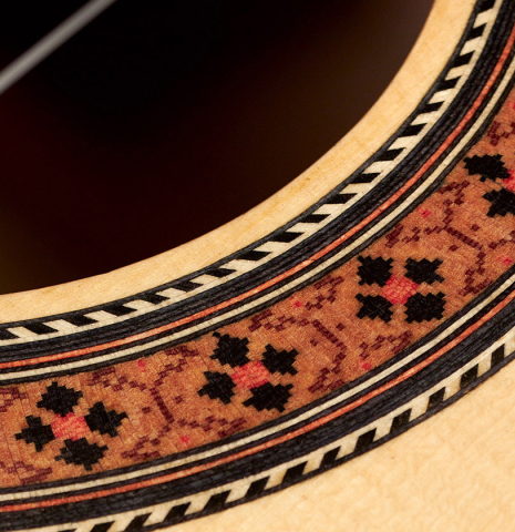 The soundboard and rosette of a 2023 German Vazquez Rubio "Classic Estudio" classical guitar made of spruce and Palo Escrito.