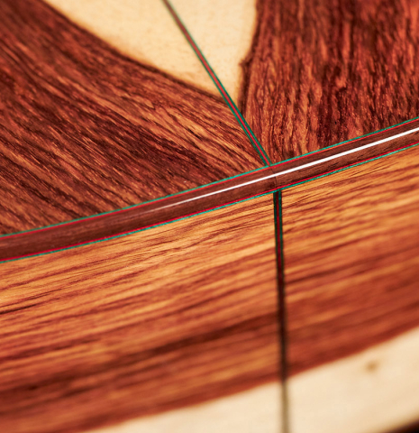 The sides and back at the foot of a 2023 German Vazquez Rubio "Classic Estudio" classical guitar made of spruce and Palo Escrito.