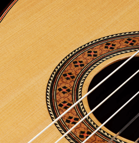 The top and rosette of a 2025 German Vazquez Rubio "Classic Estudio" classical guitar made of spruce and Palo Escrito.