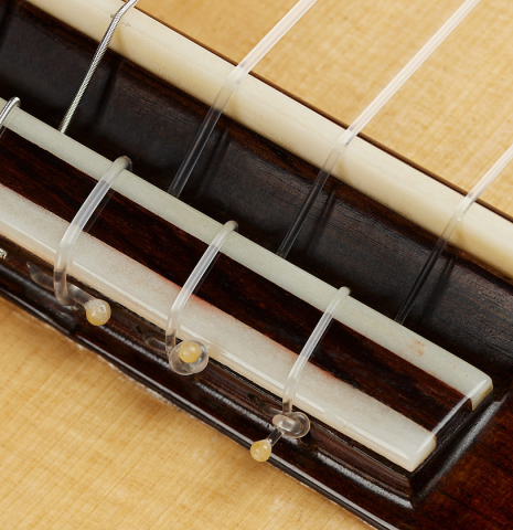 The bridge, tie-block and saddle of a 2025 German Vazquez Rubio "Classic Estudio 48" classical guitar made of spruce and palo escrito