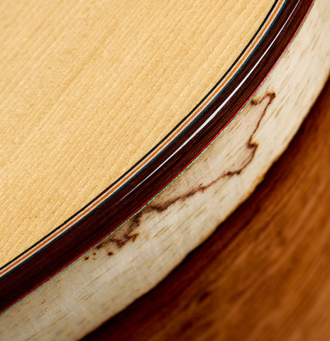 The top binding and side of a 2025 German Vazquez Rubio "Classic Estudio" classical guitar made of spruce and Palo Escrito.