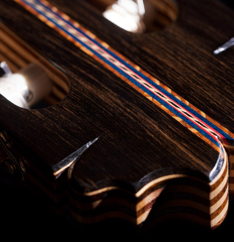 The headstock veneer of a 2021 German Vazquez Rubio "Concert 635" classical guitar made with spruce and maple