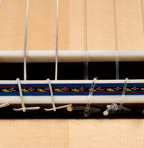 This is the bridge and saddle of a 2022 German Vazquez Rubio "Concert 635" classical guitar made with spruce and maple.