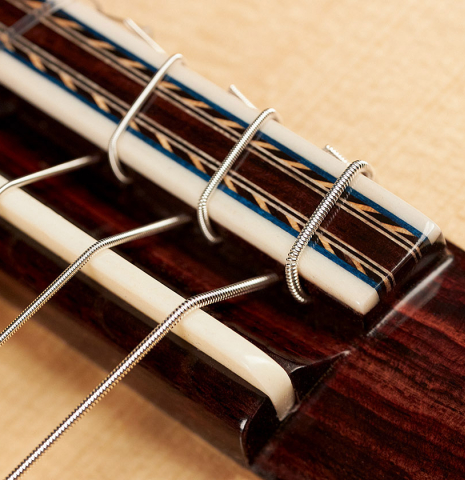 This is the bridge, tie-block and saddle of a 2023 German Vazquez Rubio "Concert 635" classical guitar made with spruce top and maple back and sides