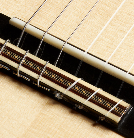 This is the bridge, tie-block and saddle of a 2023 German Vazquez Rubio "Concert 635" classical guitar made with spruce top and maple back and sides
