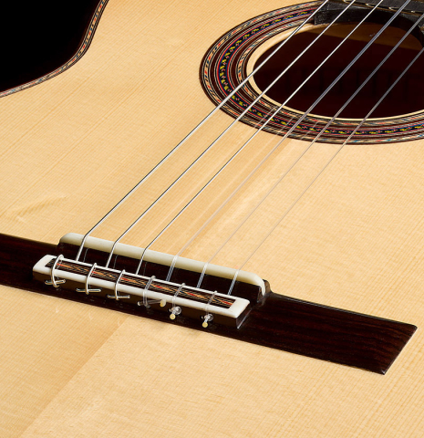 The bridge, tie-block and saddle of a 2026 German Vazquez Rubio "Concert 635" classical guitar made of spruce and maple