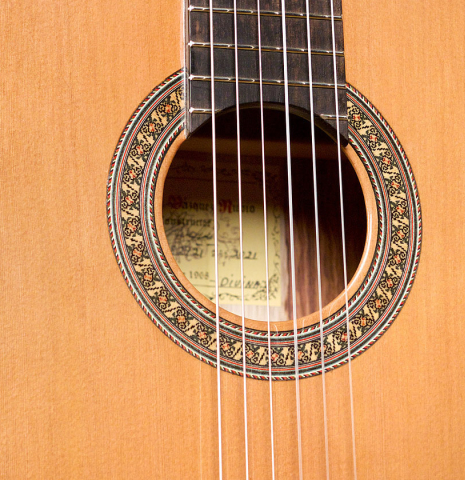The soundboard and rosette of a 2021 German Vazquez Rubio "Divina" classical guitar made with cedar and palo escrito