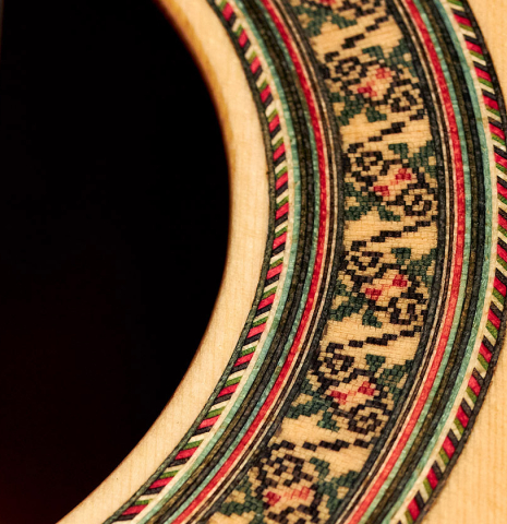 A close-up of the rosette of a 2022 German Vazquez Rubio "Divina" classical guitar made with spruce and Palo Escrito
