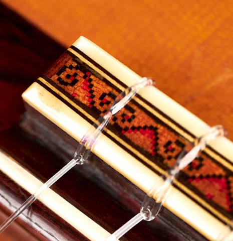 The bridge and saddle of a 1969 David Rubio classical guitar made of spruce and Indian rosewood
