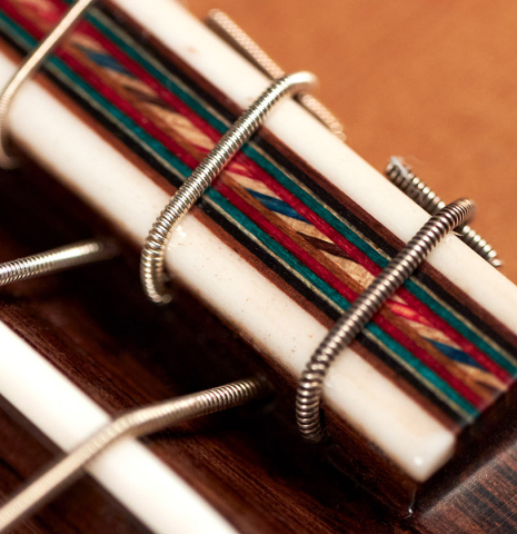 The bridge and saddle of a 2022 German Vazquez Rubio "Divina" classical guitar made of cedar and kingswood
