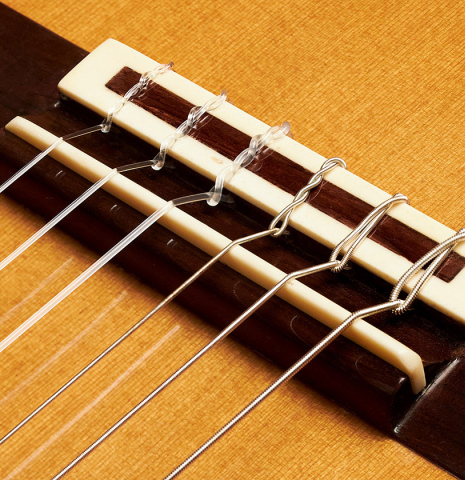 The bridge of a 1999 German Vazquez Rubio "640" classical guitar made with cedar and palo escrito
