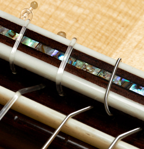 The bridge, tie-block and saddle of a 2024 German Vazquez Rubio "Hauser" classical guitar made of spruce and Indian rosewood