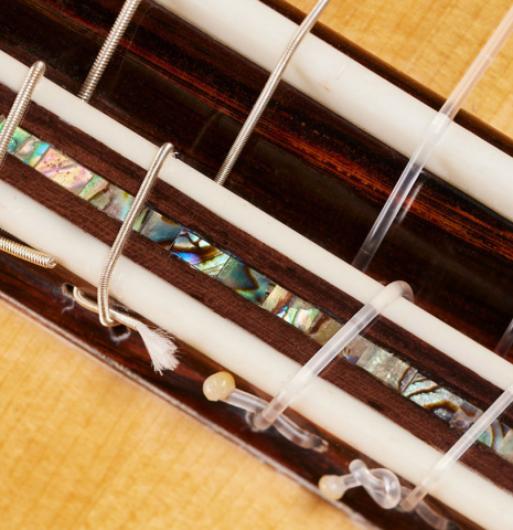 The bridge, tie-block and saddle of a 2024 German Vazquez Rubio "Hauser" classical guitar made of spruce and CSA rosewood