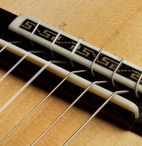 The bridge, tie-block and saddle of a 2025 German Vazquez Rubio "Solista" classical guitar made of spruce and Brazilian lacewood