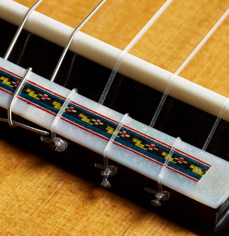 The bridge, tie-block and saddle of a 2025 German Vazquez Rubio "Solista" classical guitar made of cedar and Brazilian lacewood