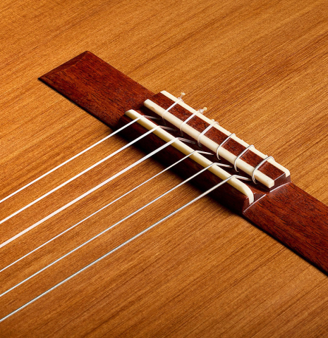 The bridge, tie-block and saddle of a 2026 German Vazquez Rubio "Classic Estudio-SM" classical guitar made of cedar and palo escrito