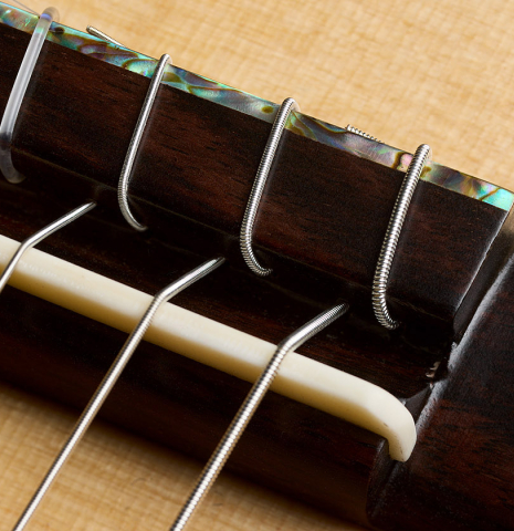 The bridge, tie-block and saddle of a 2026 German Vazquez Rubio "Classic Estudio-SM" classical guitar made of spruce and palo escrito