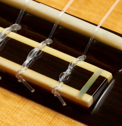 The bridge, tie-block and saddle of a 2000 Robert Ruck classical guitar made of spruce and Indian rosewood