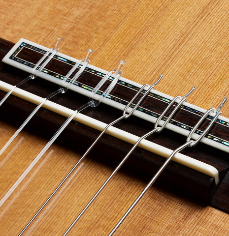 The bridge, tie-block and saddle of a 2024 Eric Sahlin classical guitar made of cedar and CSA rosewood