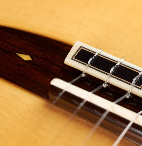 The bridge, tie-block and saddle of a 2023 Masaki Sakurai "PC" classical guitar made with spruce and CSA rosewood.