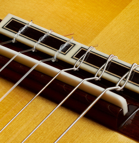 The bridge, tie-block and saddle of a 2024 Masaki Sakurai "Special" classical guitar made with spruce and African rosewood.