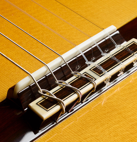 The bridge, tie-block and saddle of a 2025 Masaki Sakurai "Special" classical guitar made with spruce and African rosewood.
