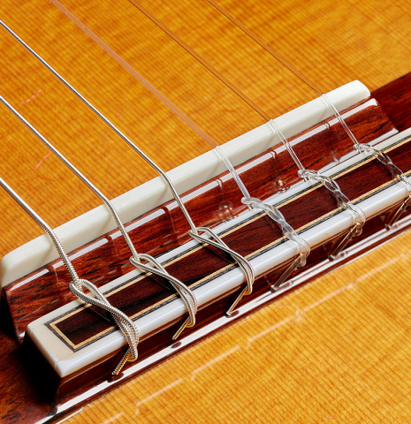 The bridge, tie-block and saddle of a 2025 Masaki Sakurai "Concert-R" classical guitar made of cedar and Indian rosewood