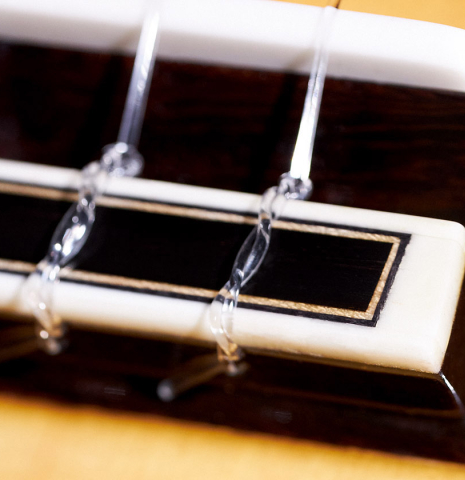 The bridge, tie-block and saddle of a 2023 Masaki Sakurai "Special 640" classical guitar made of spruce and CSA rosewood.