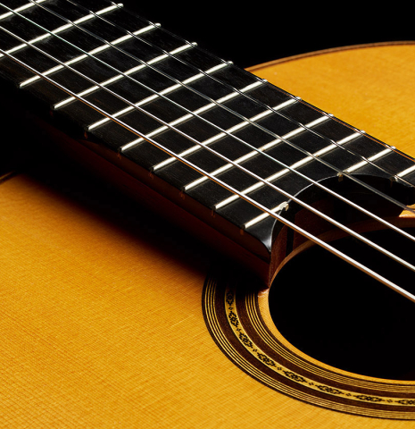 The raised fingerboard of a 2017 Masaki Sakurai "Maestro RF" classical guitar made of spruce and African rosewood