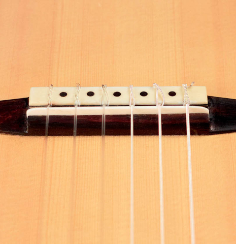 The bridge and saddle of a 2012 Arturo Sanzano &quot;Concierto&quot; classical guitar made with spruce and Indian rosewood