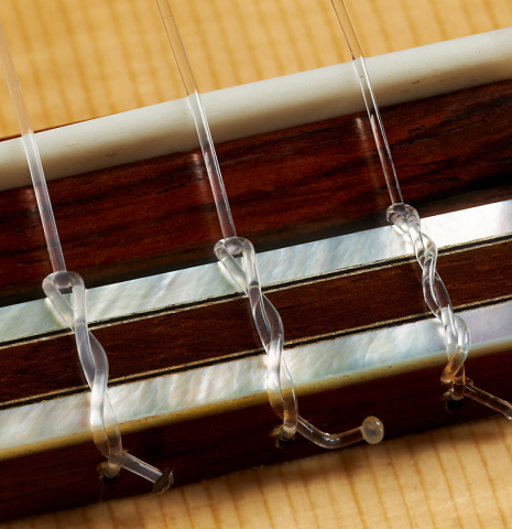 The bridge, tie-block and saddle of a 2022 Adrien Savary Freestone "Garcia" classical guitar made of spruce and CSA rosewood