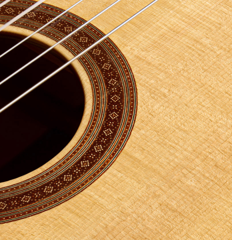 The soundboard and rosette of a 2022 Douglass Scott "635" classical guitar made of spruce and maple