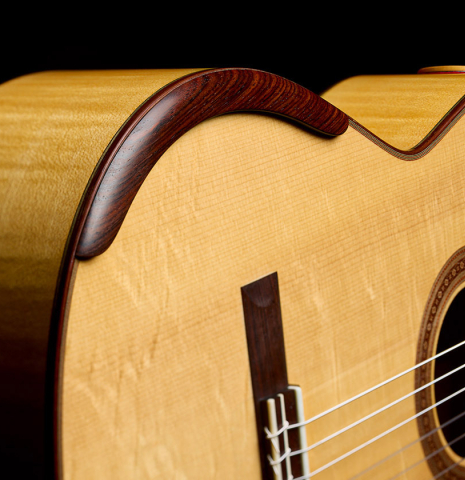 The arm-rest of a 2022 Douglass Scott "635" classical guitar made of spruce and maple