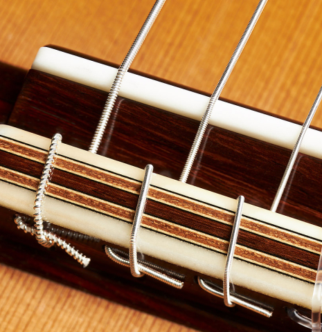 The bridge, tie-block and saddle of a 2023 Christoph Sembdner classical guitar made of cedar and exotic ebony