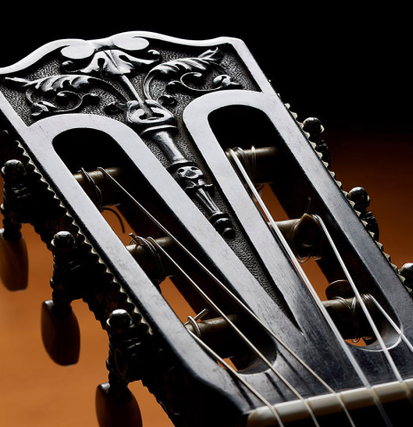 The carved headstock of a 1929 Francisco Simplicio classical guitar made of spruce and satinwood