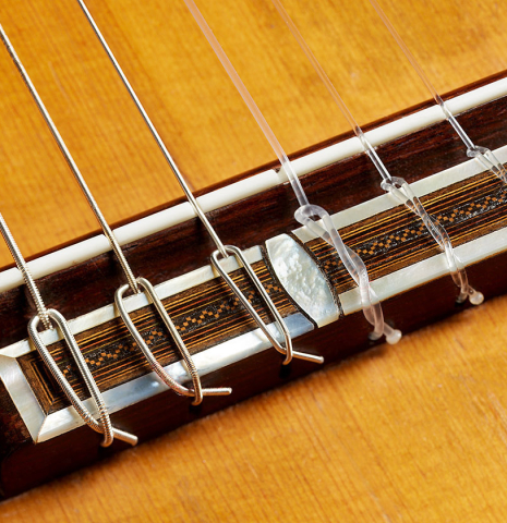 The bridge, tie-block and saddle of a 1929 Francisco Simplicio classical guitar made of spruce and satinwood