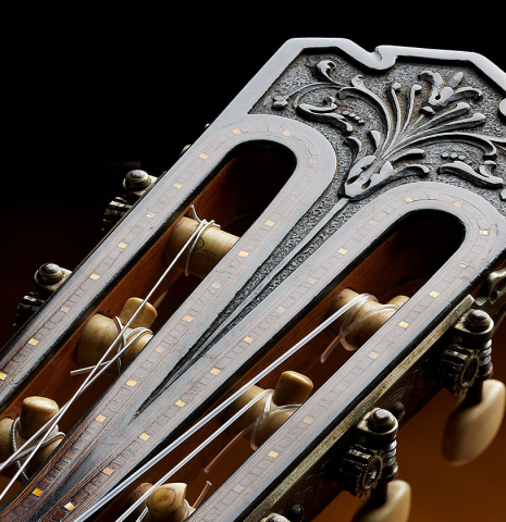 The carved and inlaid headstock veneer of a 1923 Francisco Simplicio classical guitar made of spruce and CSA rosewood