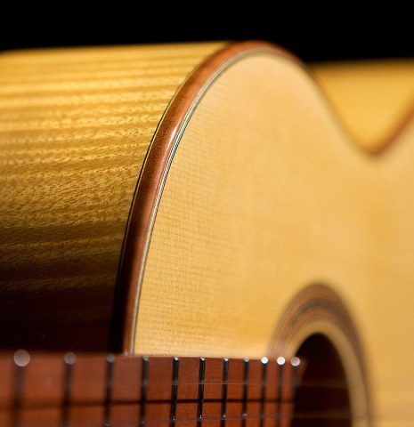 The binding and side of a 2020 Youri Soroka classical guitar made with spruce top and maple back and sides.