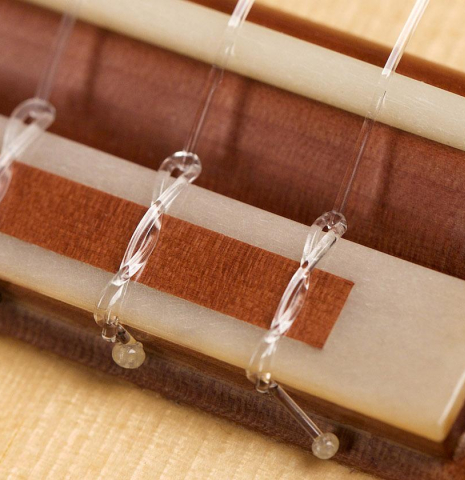 The bridge, saddle and tie block of a 2020 Youri Soroka classical guitar made with spruce top and maple back and sides.