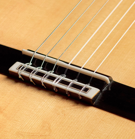 The bridge and saddle of a 2022 Youri Soroka &quot;Templars Oak&quot; classical guitar made with spruce top and oak back and sides